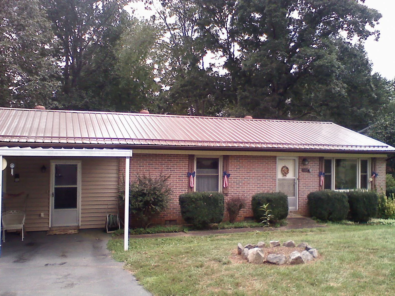 Bronze metal roof and carport on a brick ranch home — Roof Repair work by our crew in Eastport